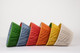 Stacked on the side Rainbow Coloured 14" Pleated Lampshades in Soprano Linen Fabric by Christopher Farr Cloth